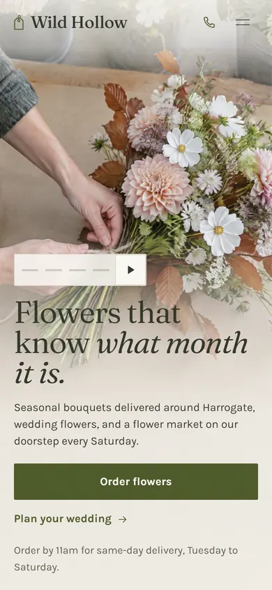 Wild Hollow florist on a phone: a hand holding a bouquet above the headline Flowers that know what month it is.